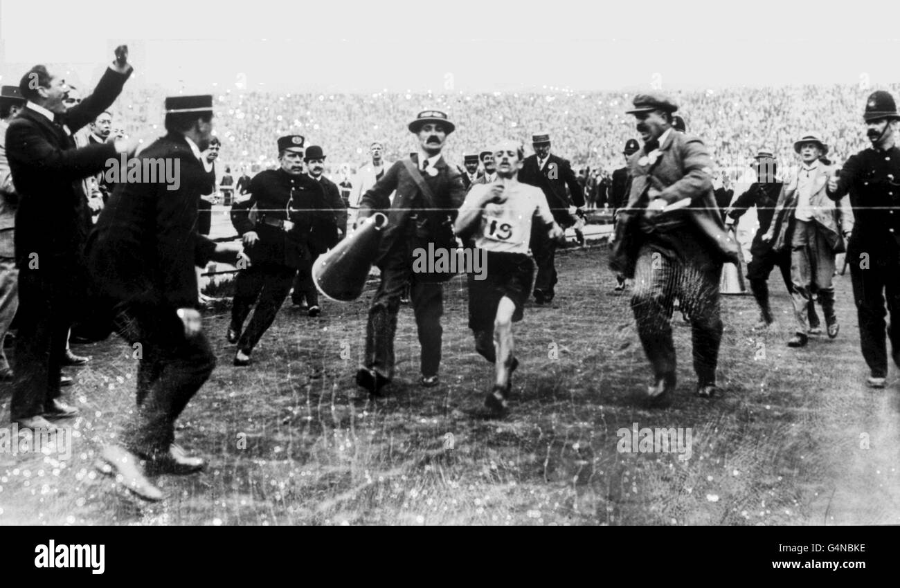 L'Italien Dorando Pietri sur le point de briser la bande pour gagner le Marathon olympique de Londres 1908. Pietri a été plus tard disqualifié pour avoir été aidé par son directeur alors qu'il était en état d'effondrement. Plus récemment, l'homme de droite assistant Dorando Pietri est considéré comme l'auteur britannique Sir Arthur Conan Doyle, mais ce n'est pas un fait prouvé. Banque D'Images