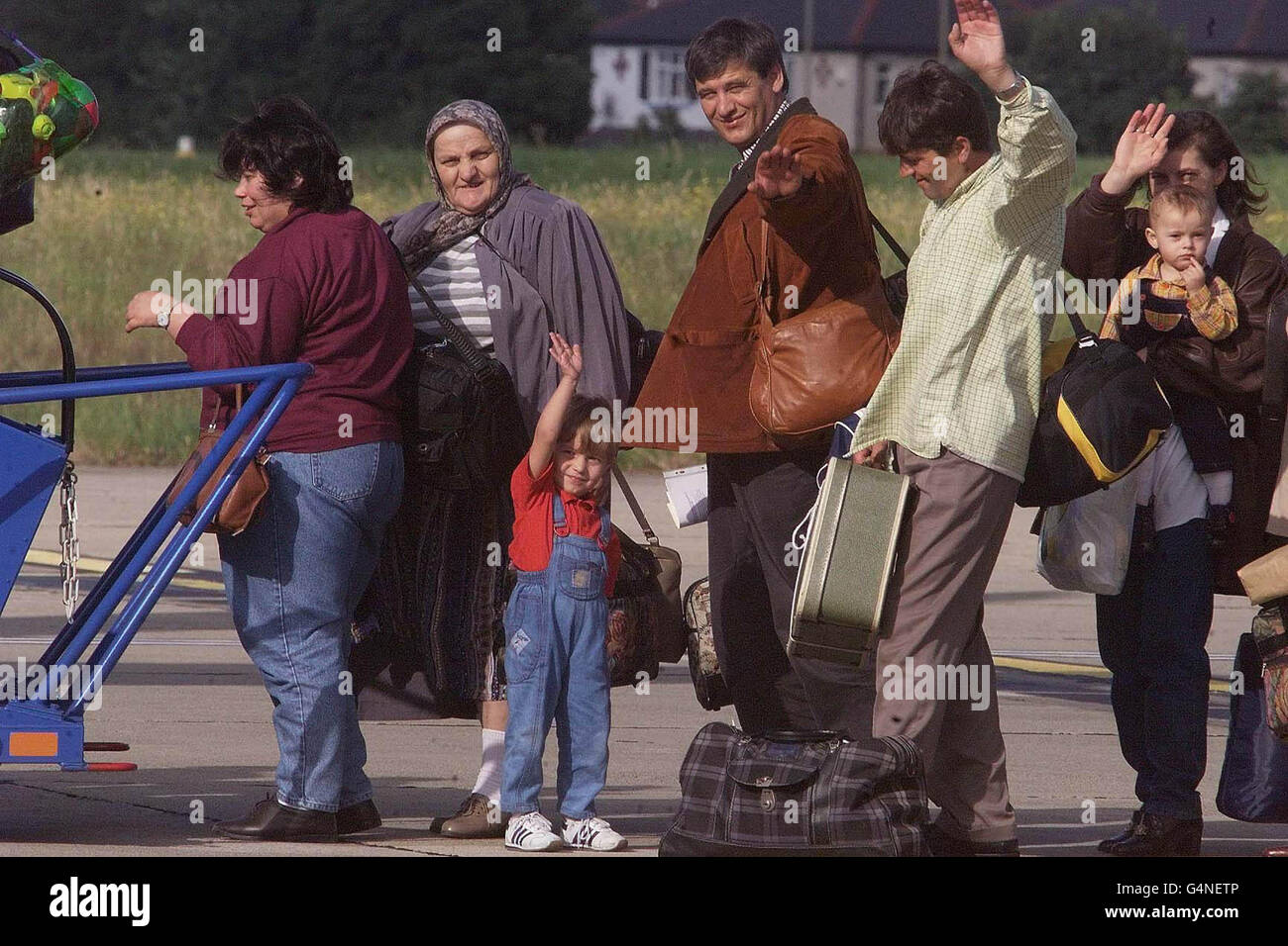 Les réfugiés kosovars affluent vers les puits de forage alors qu'ils embarquèrent dans un avion à l'aéroport de Leeds Bradford pour retourner dans leur pays. 151 réfugiés quittaient sur un vol de Macédonien Airways, trois mois et un jour depuis l'arrivée en Grande-Bretagne du premier planeload de Kosovars. * les réfugiés, qui ont chacun reçu une subvention de 250 pour les aider à redémarrer la vie dans leur patrie déchirée par la guerre, voleront à Skopje en Macédoine avant d'obtenir un autocar au Kosovo. Banque D'Images