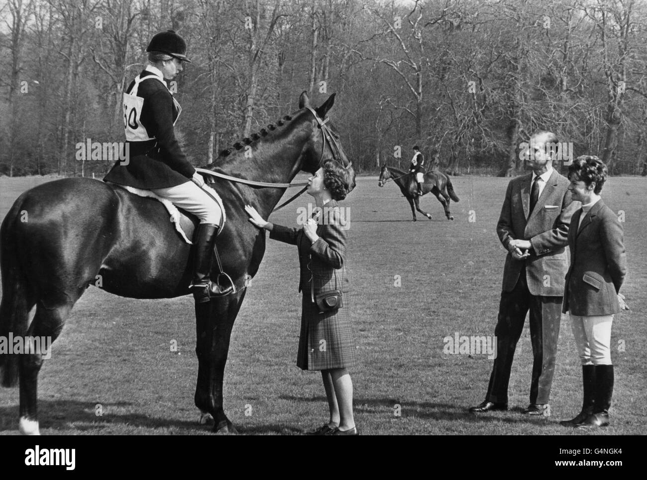 La princesse Anne, montée sur l'océan Royal, reçoit un certain encouragement de la part de la reine, sous la surveillance du duc d'Édimbourg et d'Alison Oliver, épouse de l'un des concurrents du saut de spectacle, lors des essais hippiques de Windsor Park à Windsor Great Park. Banque D'Images