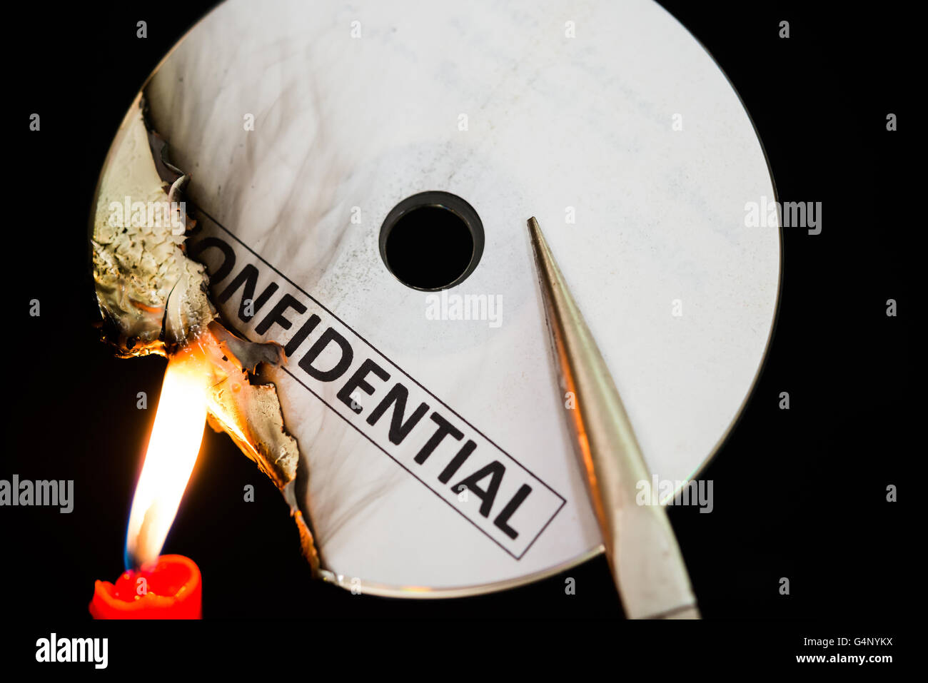 La gravure d'un disque compact confidentiel avec une bougie dans le noir SS Banque D'Images