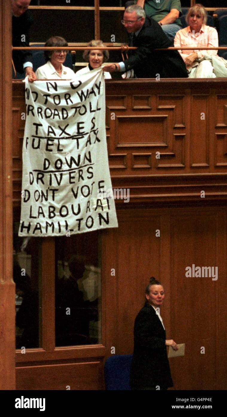 Un manifestant a été éjecté de la première session du Parlement écossais, après avoir levé une bannière protestant contre la taxation des routes et des carburants par le Parti travailliste. Banque D'Images