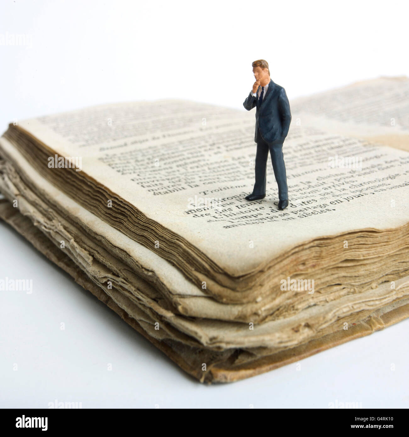 L'homme, miniature, figurine, debout sur un vieux livre Banque D'Images