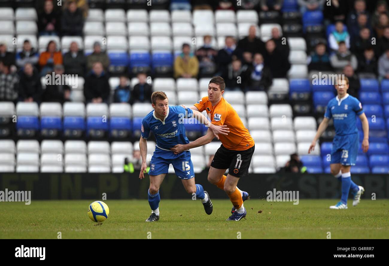 Stephen Ward de Wolverhampton Wanderers (à droite) et Wade Elliott de Birmingham City (à gauche) lutte pour le ballon car les sièges vides sont visibles dans les supports Banque D'Images