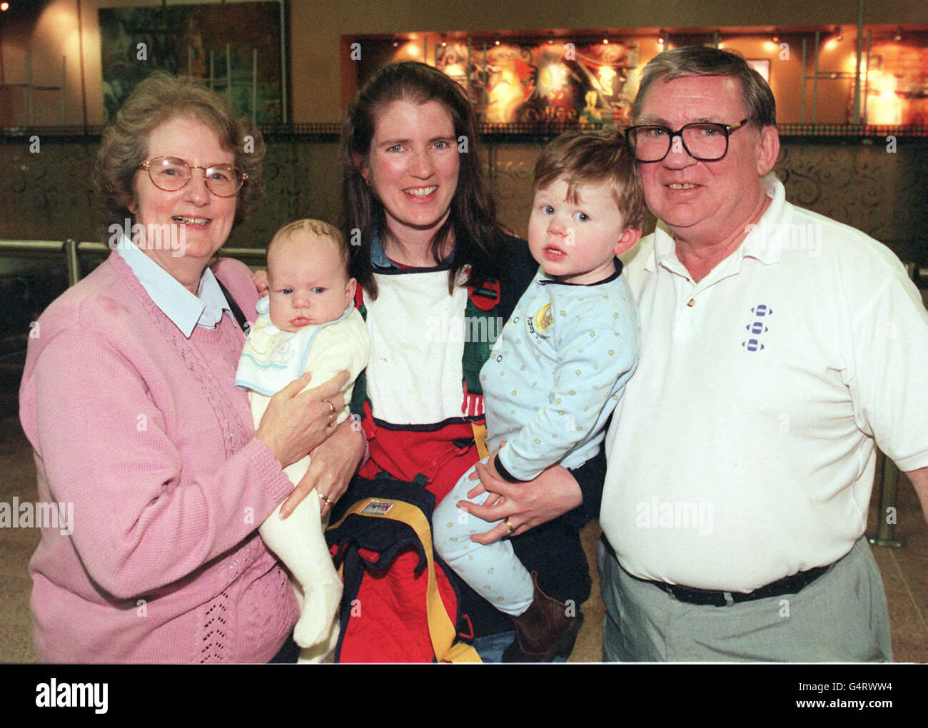 Sharon Dolly, 29 ans, avec ses fils Nicholas, 16 semaines et Alexander, deux, est rencontré par ses parents Maureen et Tony Palin, de Denton, Manchester, à l'aéroport d'Heathrow, alors que les passagers du vol malade QF001 de Sydney ont finalement atteint leur destination. * le Boeing 747-400 de Qantas avec 407 passagers à bord s'est écrasé de l'extrémité de la piste à l'atterrissage lors d'une tempête tropicale à l'aéroport de Bangkok, a glissé hors de la piste d'atterrissage et a endommagé le nez de l'avion, le train d'atterrissage et les moteurs comme il a glissé à un arrêt. Banque D'Images