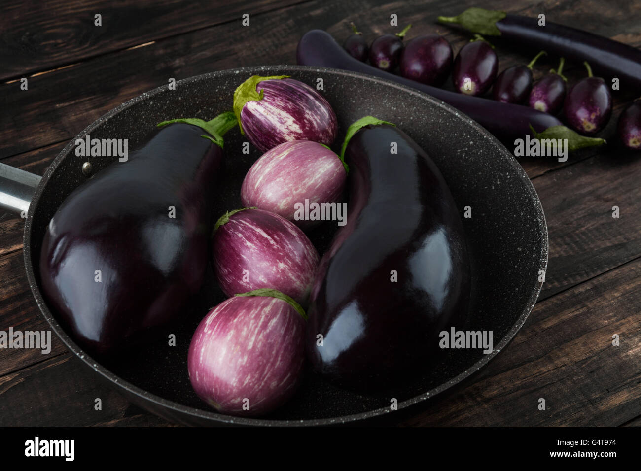 Variétés d'aubergine sur table en bois - Classic black magic, violet rayé, bébé, et Japonais d'aubergines Banque D'Images