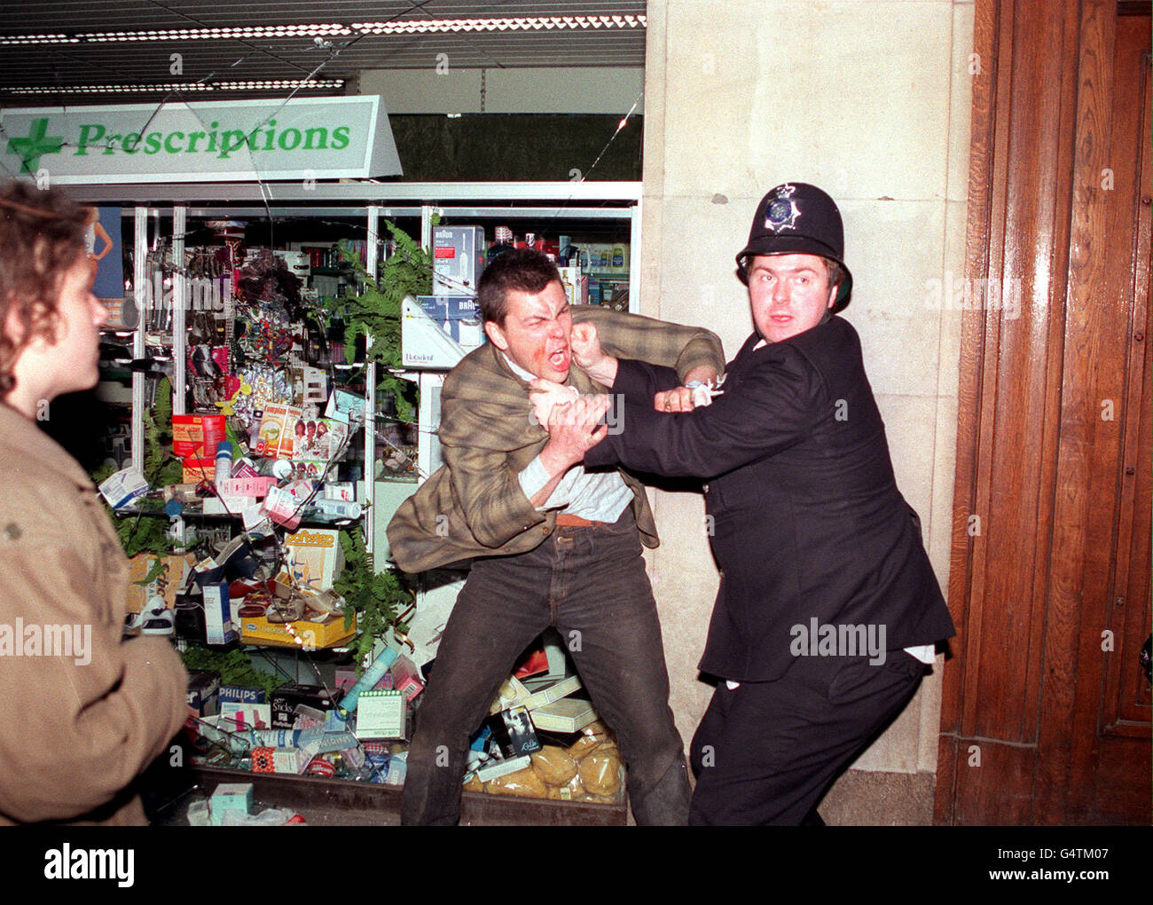 Un policier s'en va avec un homme dans la rue Lower Regent lors des émeutes d'aujourd'hui dans le centre de Londres qui ont éclaté à la fin d'une manifestation contre les impôts. Banque D'Images