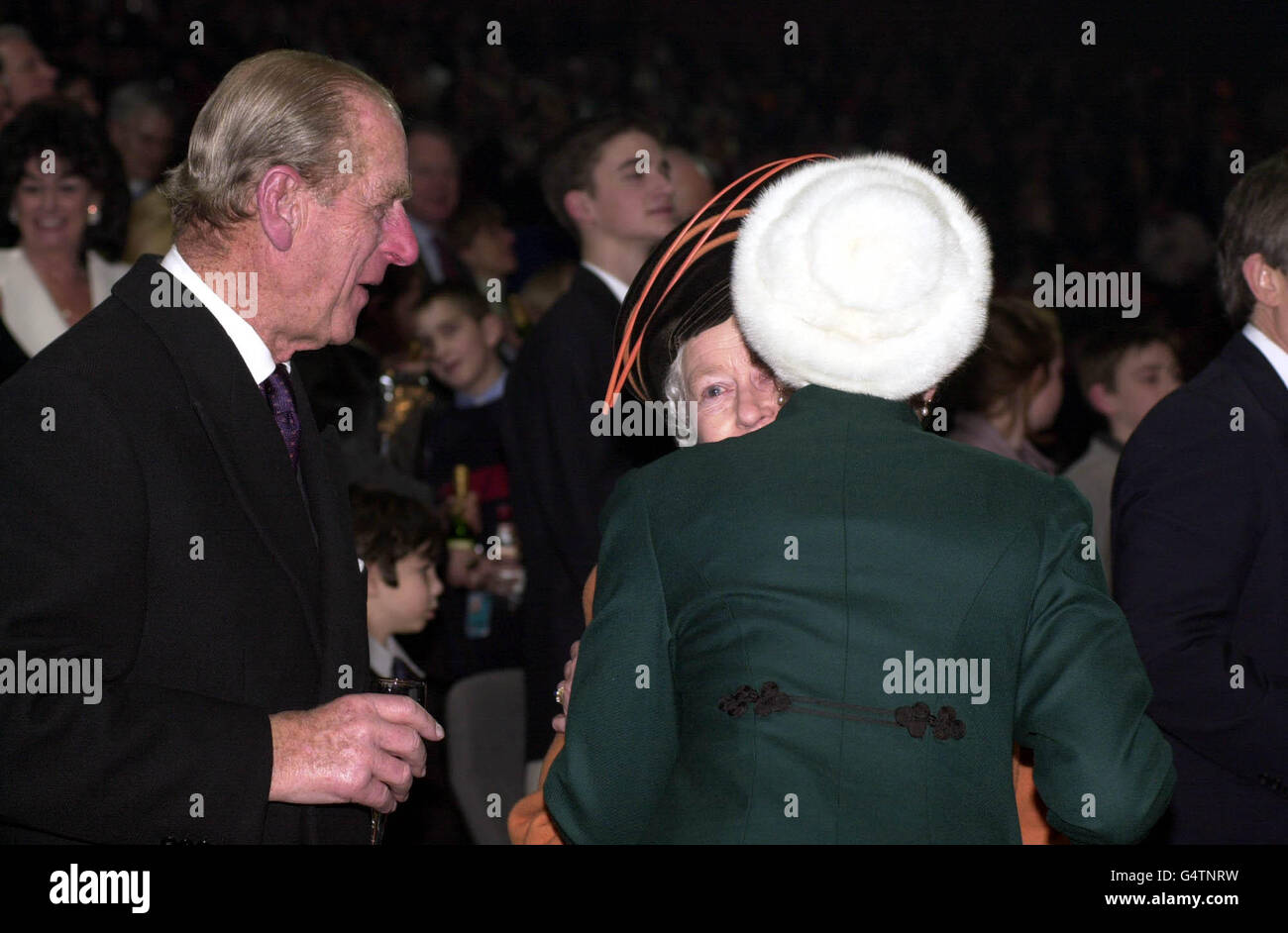 La Reine reçoit un baiser de sa fille la Princesse Royale alors que le duc d'Édimbourg regarde pendant les célébrations de minuit au Millennium Dome de Greenwich, dans le sud-est de Londres.* la reine Elizabeth II de Grande-Bretagne et son mari sont parmi le public de la Saint-Sylvestre pour l'ouverture du Dôme, qui sera la pièce maîtresse des célébrations du millénaire du Royaume-Uni.Photo PA : Fiona Hanson *EDI Banque D'Images