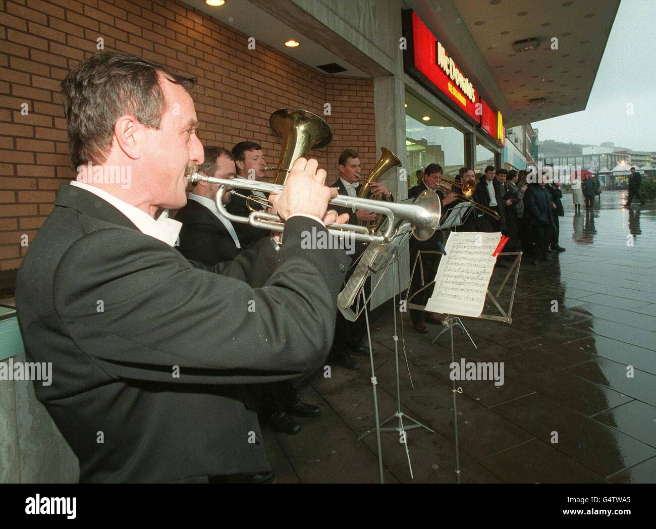 Vladimir Vasilin et d'autres membres de l'Orchestre National Philharmonique de Russie jouent aux acheteurs de la place du Château de Swansea pour promouvoir leurs performances au Brangwyn Hall, le 25 novembre 1999.L'orchestre a été forcé à busk après que les mauvaises ventes de billets pour leur tournée au Royaume-Uni ont conduit les musiciens à survivre sur du pain et du fromage et à dormir 10 dans une chambre dans les auberges de jeunesse.Voir PA Story SHOWBIZ Orchestra.Photo de Gayle Marsh/SWEP 99-11-25/8807/GM P1 Banque D'Images