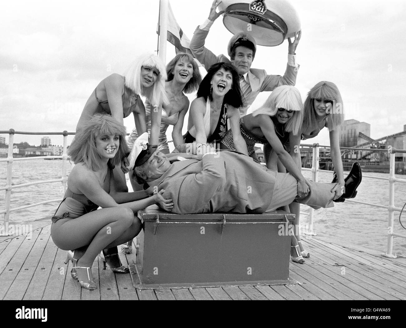 Sir Harry Secombe reçoit l'attention de six dames et du présentateur de la série télévisée 3-2-1, Ted Rogers, lors d'une croisière sur la Tamise sur la MV Queen Elizabeth, organisée par Yorkshire TV, pour lancer leurs productions de divertissement léger pour 1982. Banque D'Images
