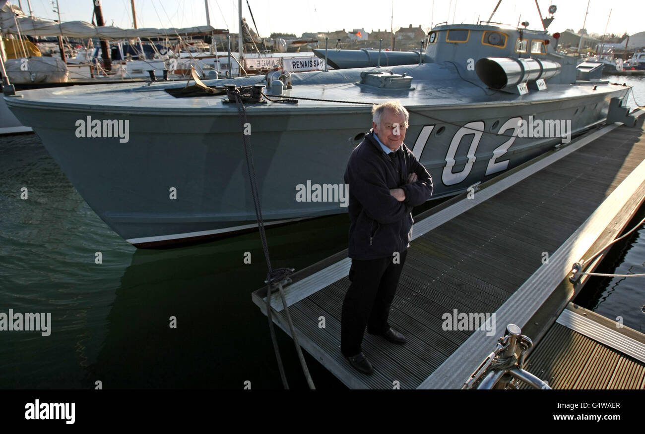 Richard Basey, se dresse le long du bateau Motor Torpedo 102, attaché à Oulton Broad, Lowestoft, Suffolk. Banque D'Images