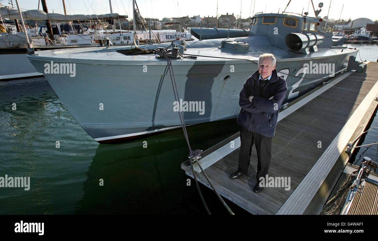 Richard Basey se tient le long du Motor Torpedo Boat 102, attaché à Oulton Broad, Lowestoft, Suffolk. Banque D'Images