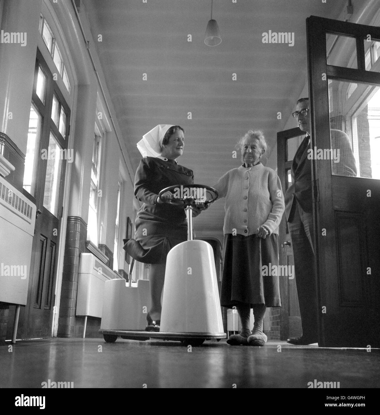 Irene Watkins, première matronne mécanique de Londres, connue de ses patients sous le nom de Flying Angel, arrête son scooter de 7 km/h pour parler avec Caroline Allen, âgée de 101 ans, lors d'une visite des quartiers de Ladywell Lodge Old People's Home à Lewisham. Elle avait l'habitude de marcher jusqu'à 14 milles par jour lorsqu'elle visitait les 691 résidents de la maison. Maintenant, le conseil de Lewisham lui a fourni le scooter spécial. Banque D'Images