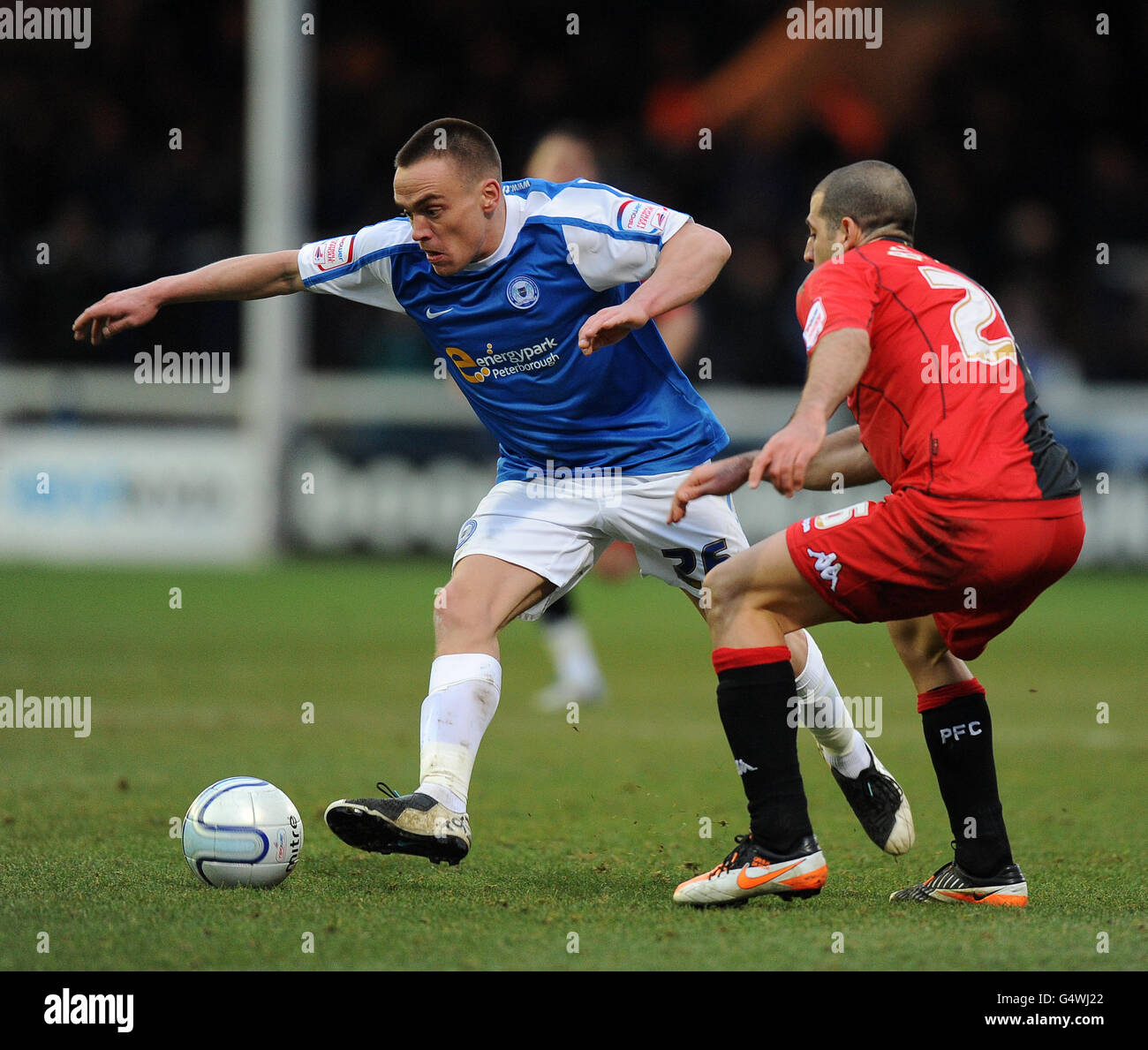 Paul Taylor (à gauche) de Peterborough United et Tal Ben Haim de Portsmouth bataille pour le ballon Banque D'Images