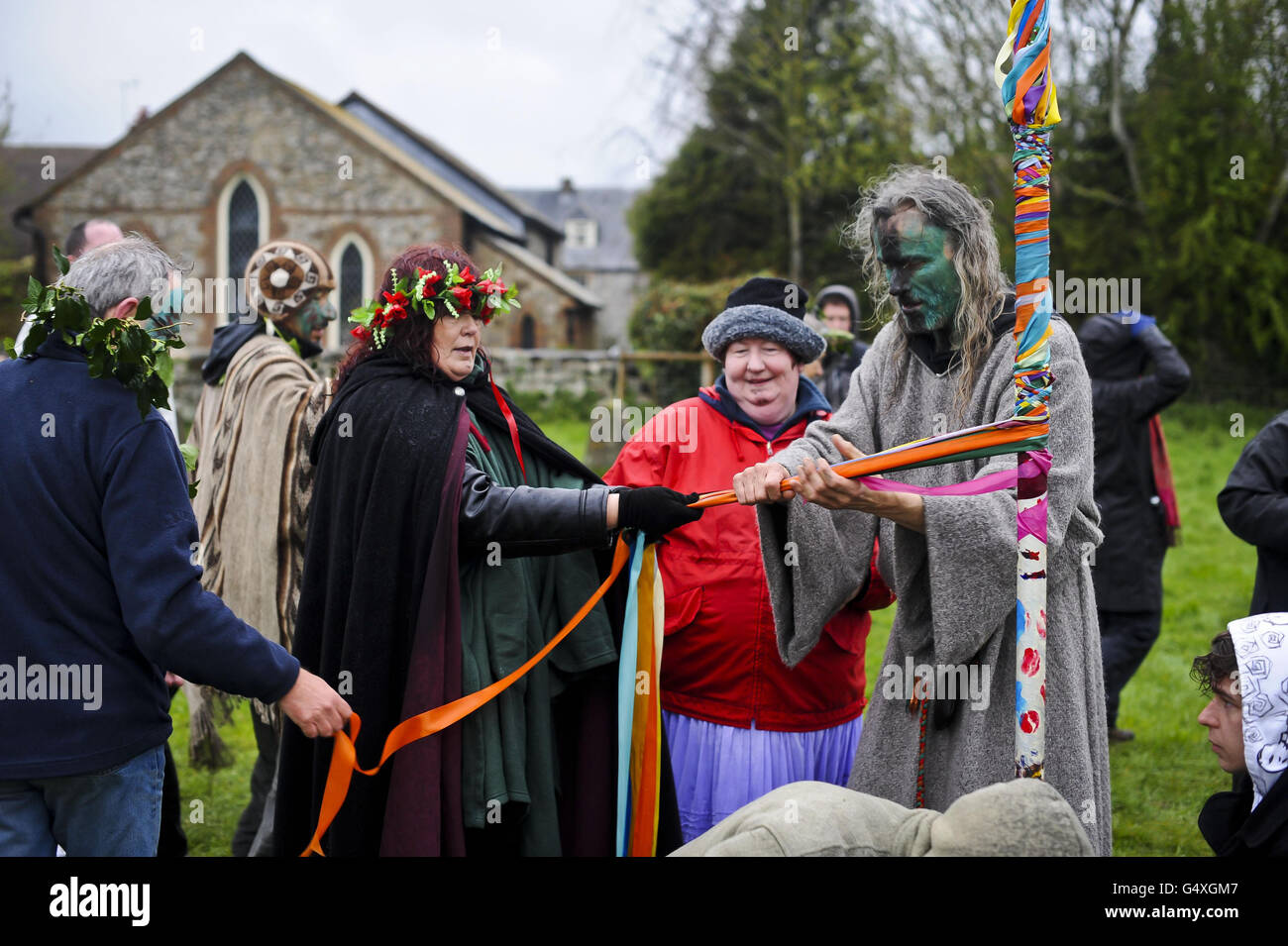 Des rubans sont attachés à la fin de la danse de la maypole à l'Avebury Stone Circle, dans le Wiltshire, où les Pagans se sont avéré célébrer le Beltane alors que le soleil se lève derrière un ciel nuageux. Banque D'Images
