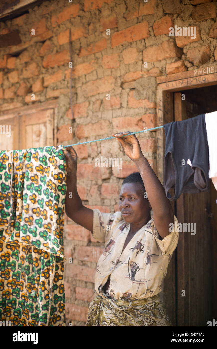 Une femme raccroche lave devant sa maison dans le district de Kasese, Ouganda, Afrique de l'Est. Banque D'Images