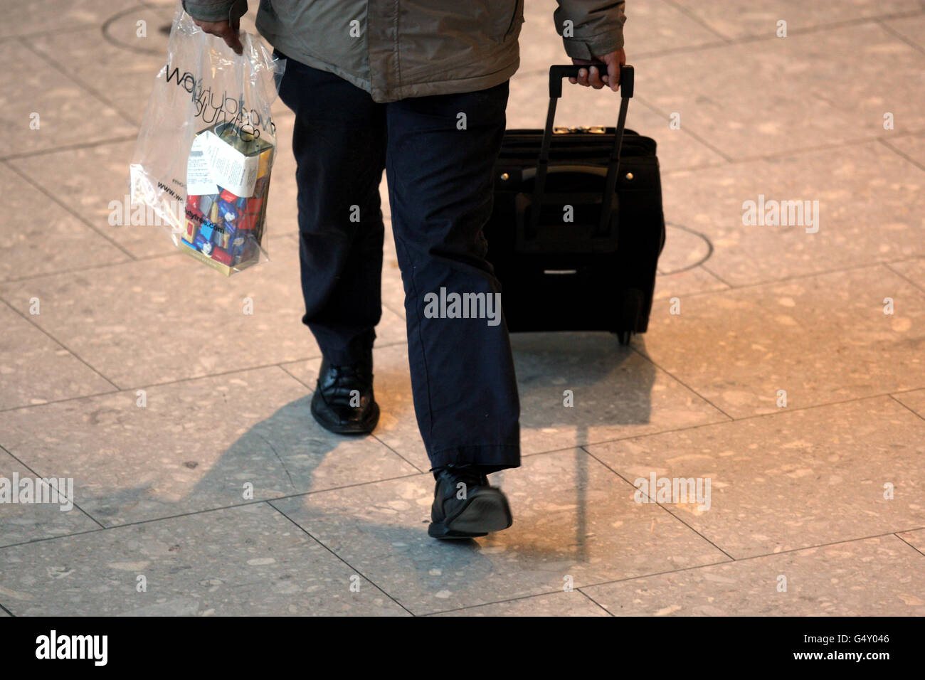 Un passager pousse ses bagages dans le terminal 5 de Heathrow Aéroport Banque D'Images