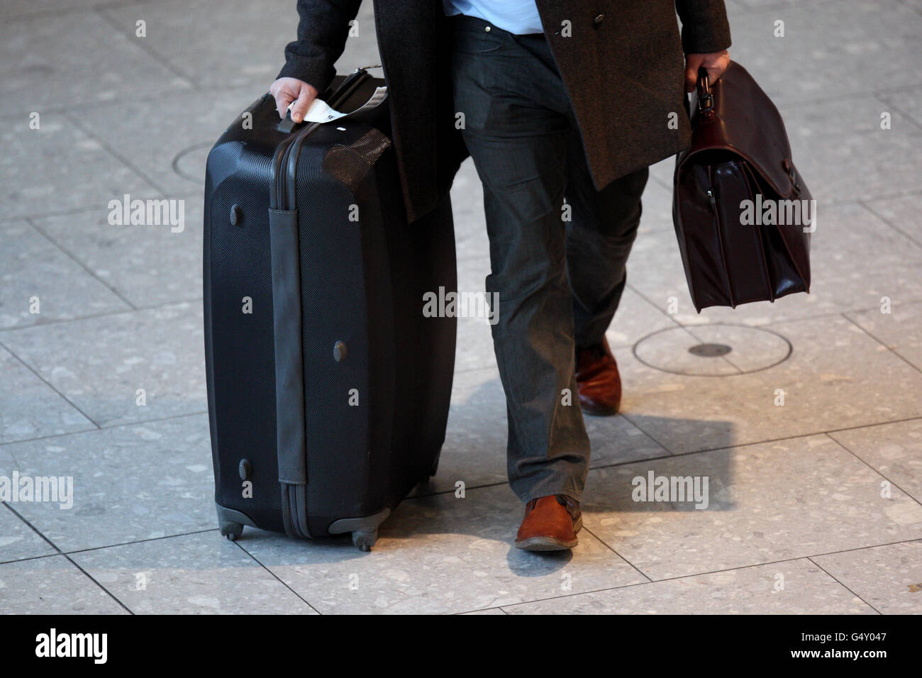 Un passager pousse ses bagages dans le terminal 5 de Heathrow Aéroport Banque D'Images
