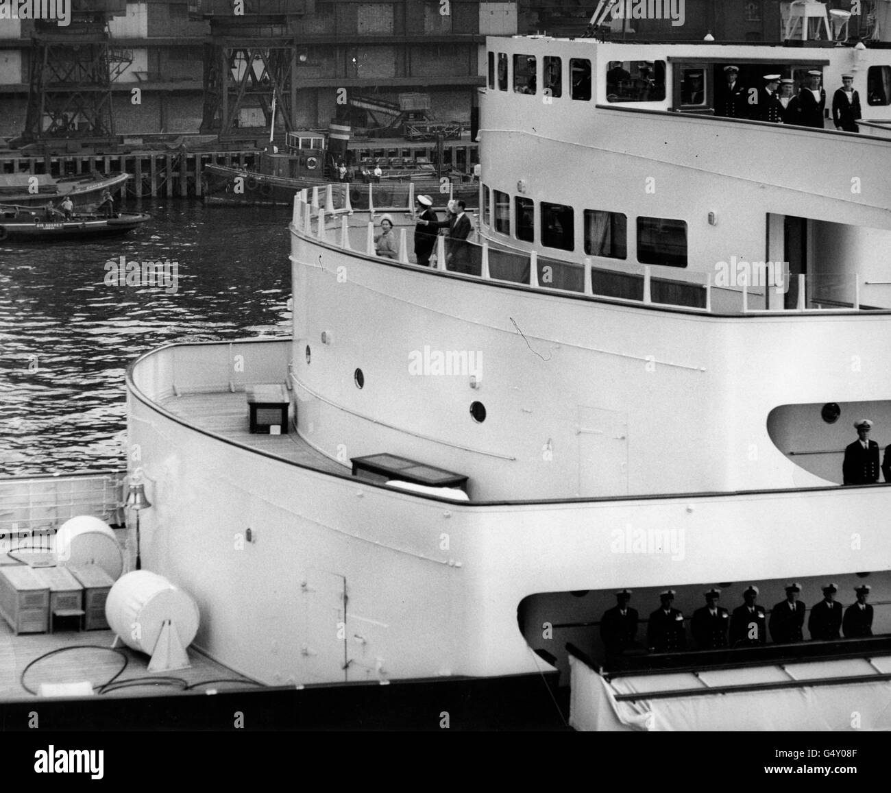 *numérisé basse résolution de la version imprimée* la reine Elizabeth II agitant du yacht royal Britannia aux foules enthousiastes de Tower Bridge quand le yacht royal passe sous le pont à son départ de la piscine de Londres. Banque D'Images