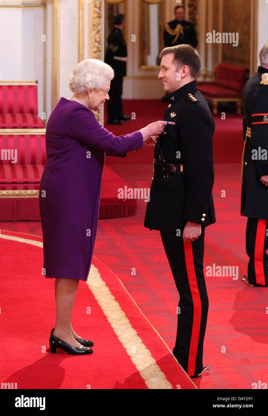 Le Capitaine Steven Jones, corps de l'Armée de terre, est décoré de la Croix de l'Armée de l'Air, pour des services en Afghanistan par la reine Elizabeth II au palais de Buckingham, dans le centre de Londres. Banque D'Images