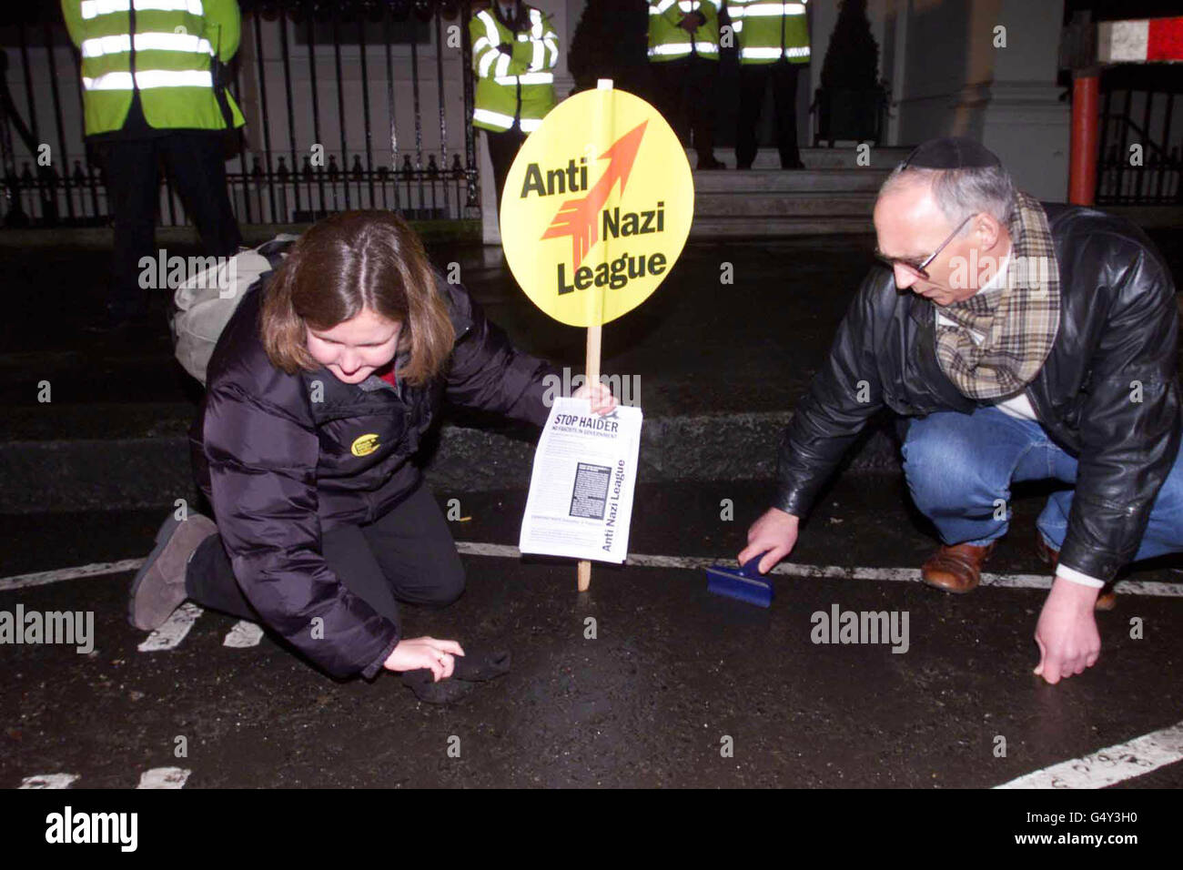 Claire Dissington, de la Ligue anti-nazie, et le protestant Burrough Ben-David scrutent la rue devant l'ambassade d'Autriche à Londres, dans la mémoire symbolique de ce que les Juifs viennois ont été faits pour faire sous le régime nazi.* ...suite à l'inclusion du politicien autrichien d'extrême-droite Joerg Haider dans le gouvernement du pays. Banque D'Images