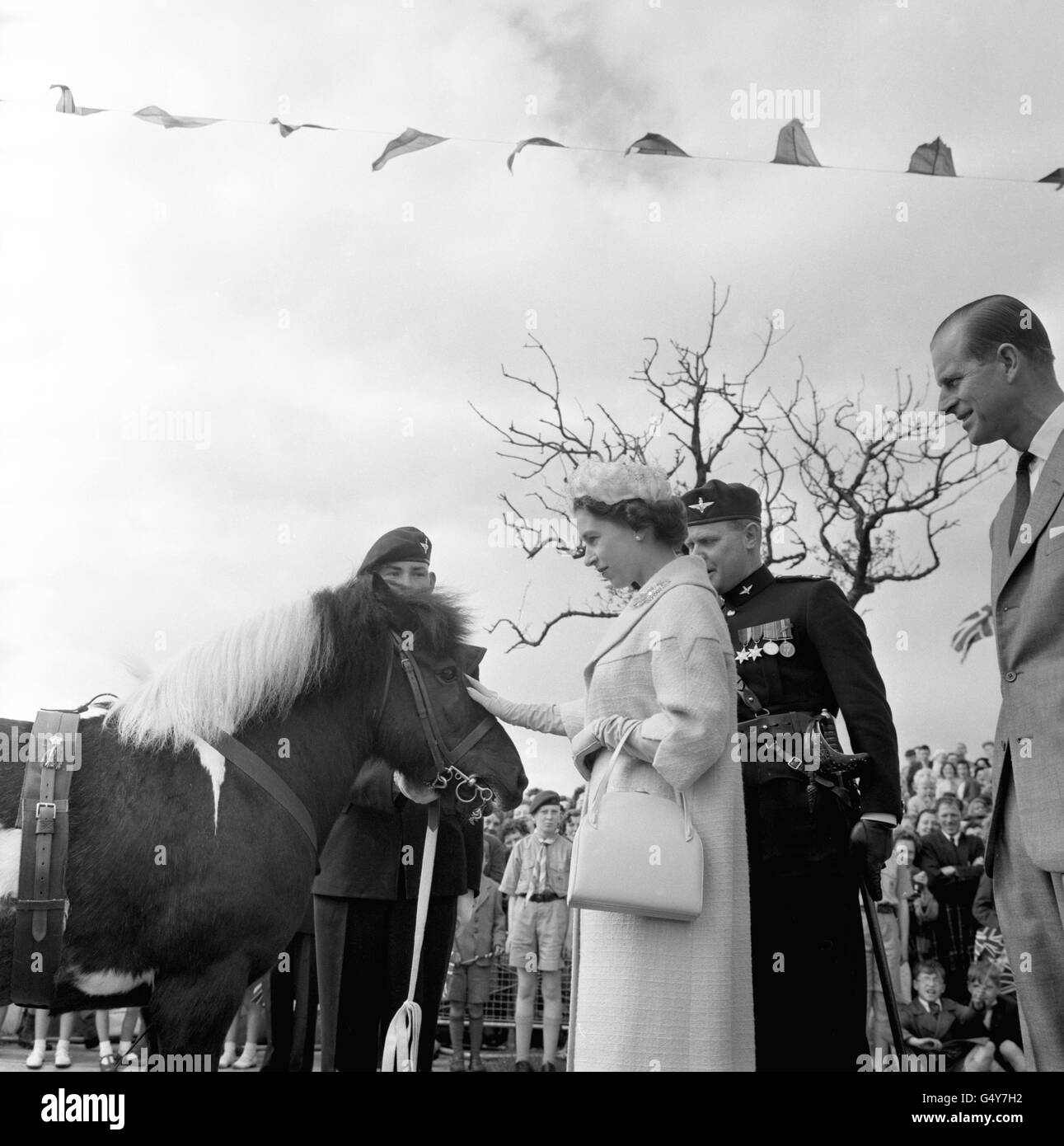 La reine Elizabeth II pats Geordie, mascotte du 17e Bataillon parachute Regiment (9e Durham Light Infantry), lors d'une visite à Peterlee, dans le comté de Durham. Le duc d'Édimbourg se trouve sur la droite. Banque D'Images