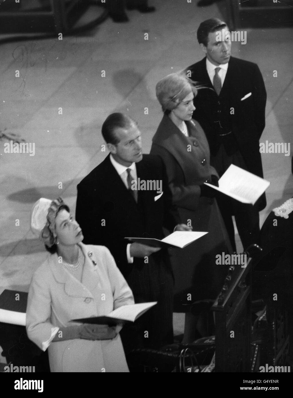 La reine Elizabeth II regarde et d'autres membres du parti royal font face à la porte ouest alors que l'évêque de Guildford demande l'entrée pendant la consécration de la nouvelle cathédrale de Guildford. Elle est accompagnée du duc d'Édimbourg, de la princesse Margaret et d'Antony Armstrong-Jones. Banque D'Images