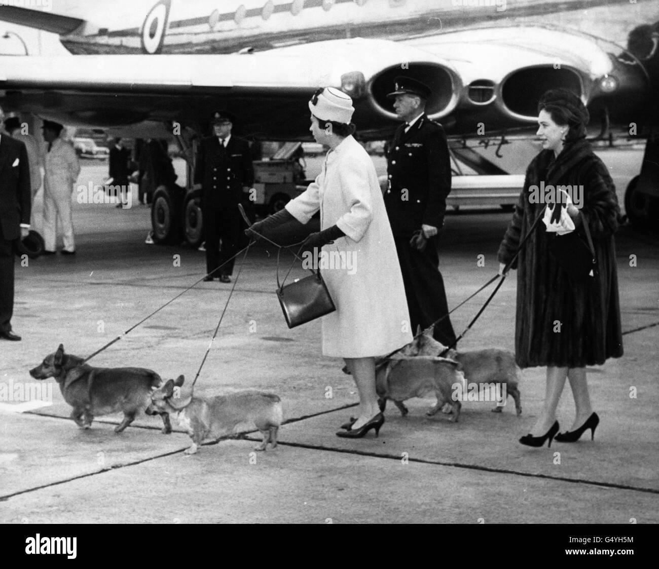 La reine Elizabeth II et sa sœur, la princesse Margaret, dirigent leur animal de compagnie sur le bon chemin depuis l'avion royal à l'arrivée à l'aéroport d'Heathrow. Banque D'Images