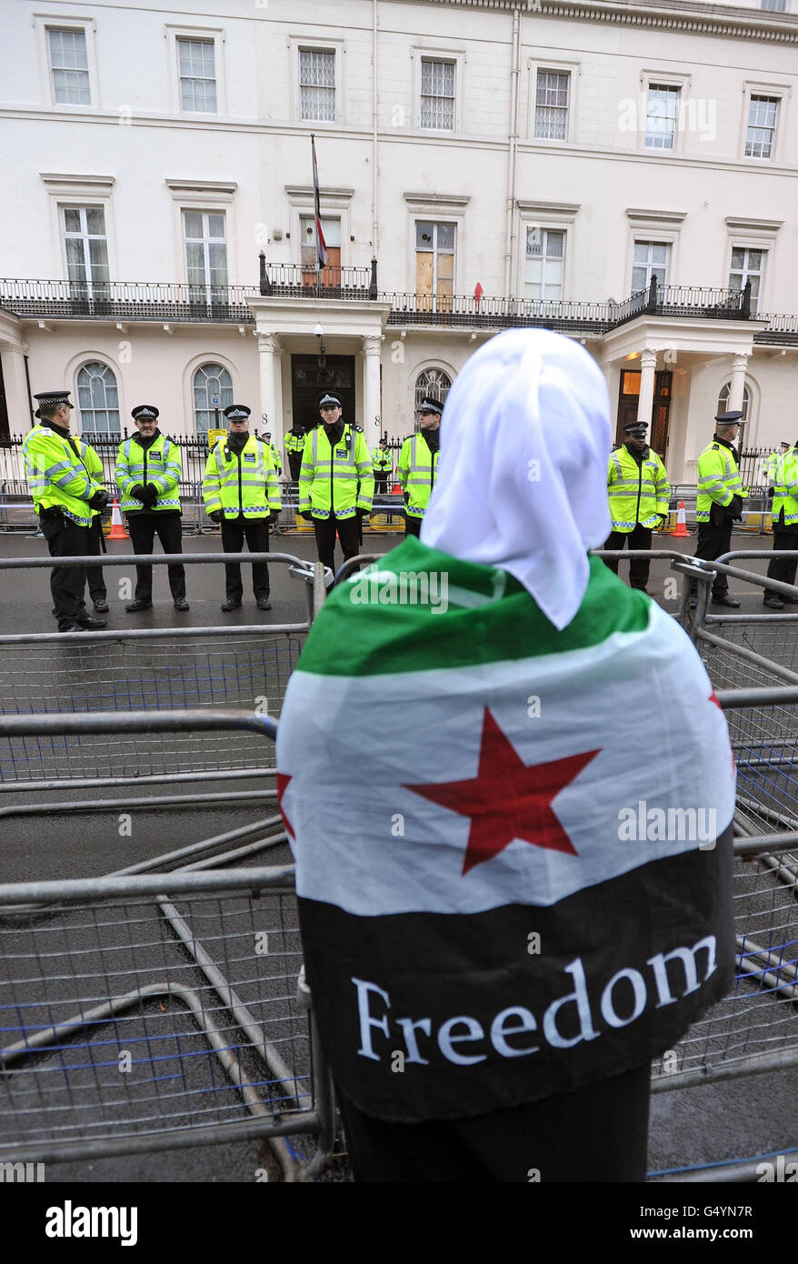 Une femme enveloppée dans un drapeau syrien en tant que protestataire devant l'ambassade syrienne à Belgrave Square, dans le centre de Londres, démontre l'escalade du conflit en Syrie. Banque D'Images