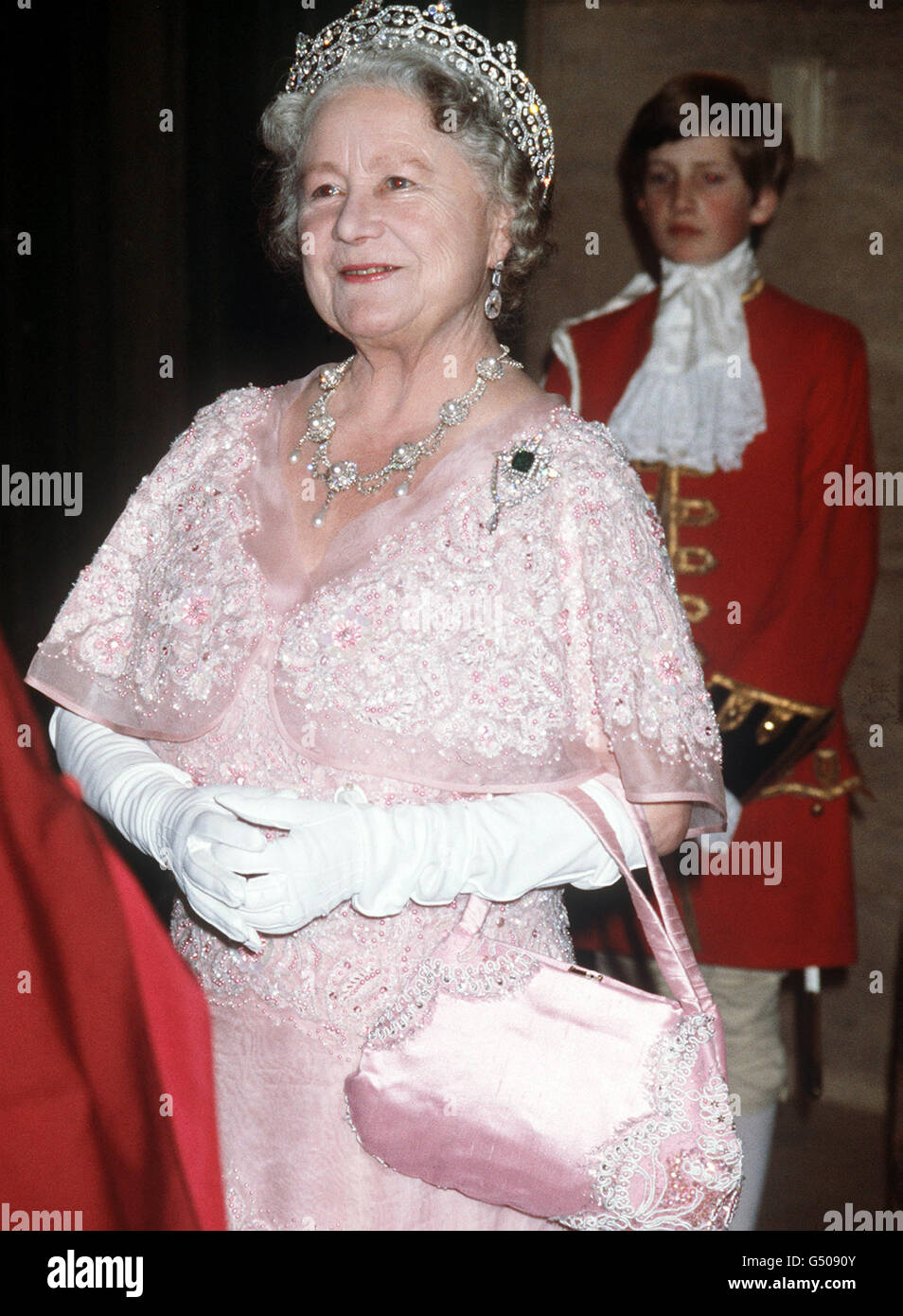 La Reine mère dans ses robes comme chancelière de l'Université, à l'Université de Londres quand elle a assisté au dîner du jour de la Fondation et a conféré des diplômes honorifiques. Le transport de son train est M. Henry Beaumont. Banque D'Images