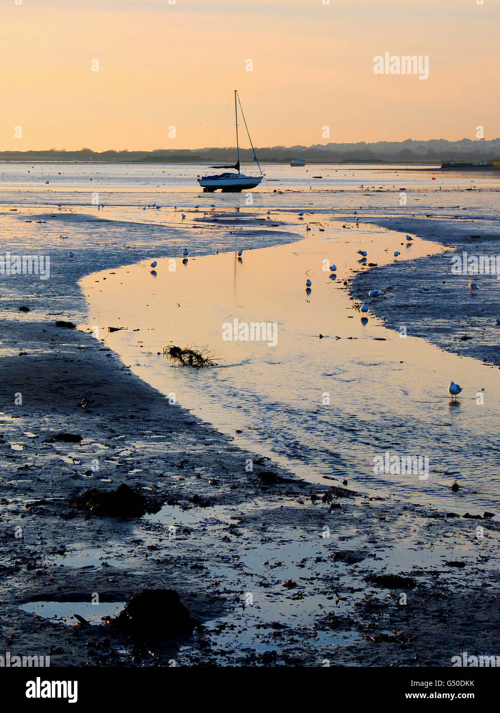 Un voilier en appui sur le sable de Mudeford, clé de Christchuch. La rivière Mude peut être vu couler dans la baie. Banque D'Images