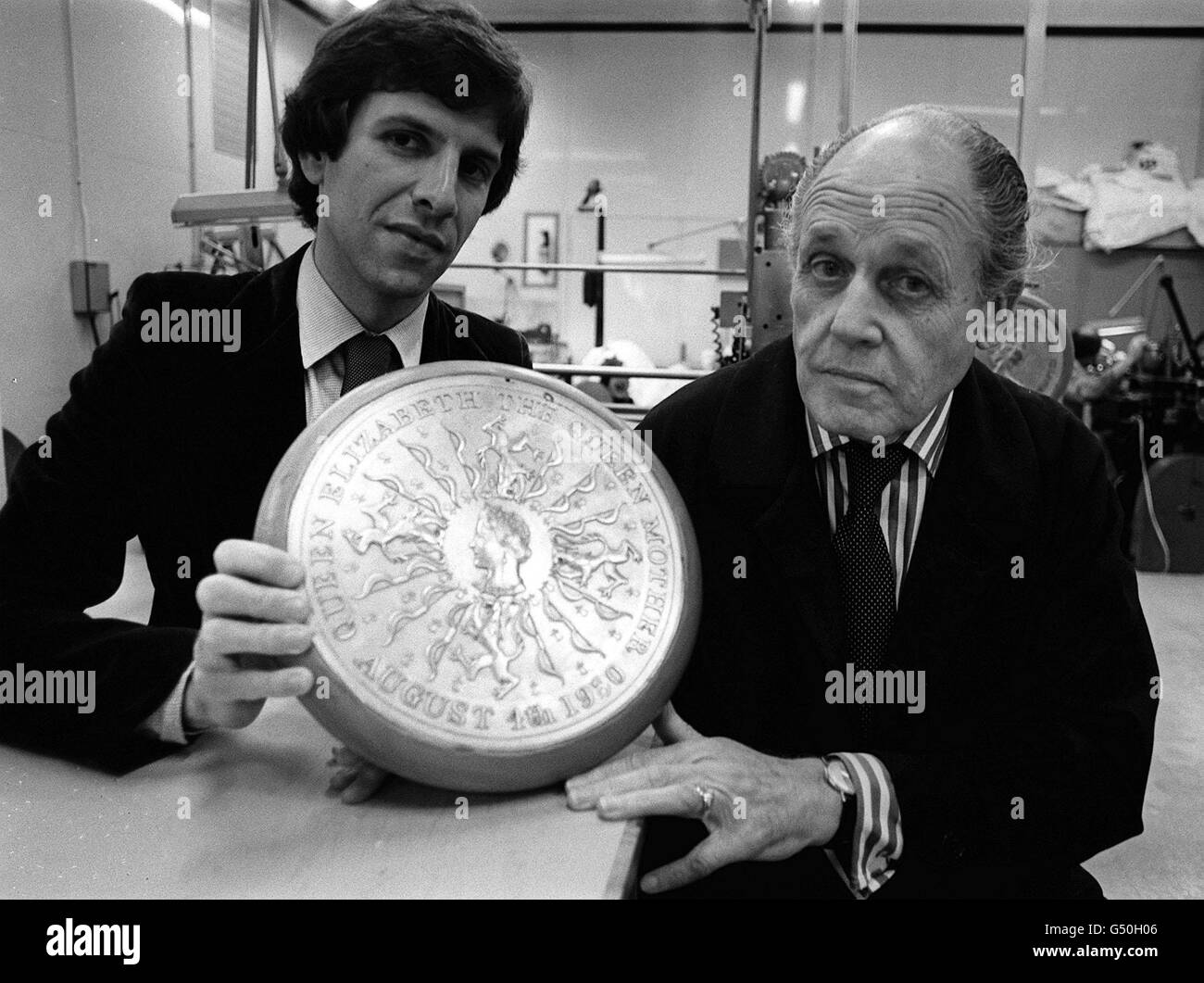 Robert Elderton (L) tenant l'électro-type avec lequel une nouvelle couronne de 25 pence a été frappée en commémoration du 80e anniversaire de la reine mère, à la monnaie royale de Llantrisant, au sud du pays de Galles. Elderton est avec Richard Guyatt (R). * ...un professeur d'arts graphiques au Royal College of Art, avec lequel Elderton a travaillé pour le design gagnant. Banque D'Images