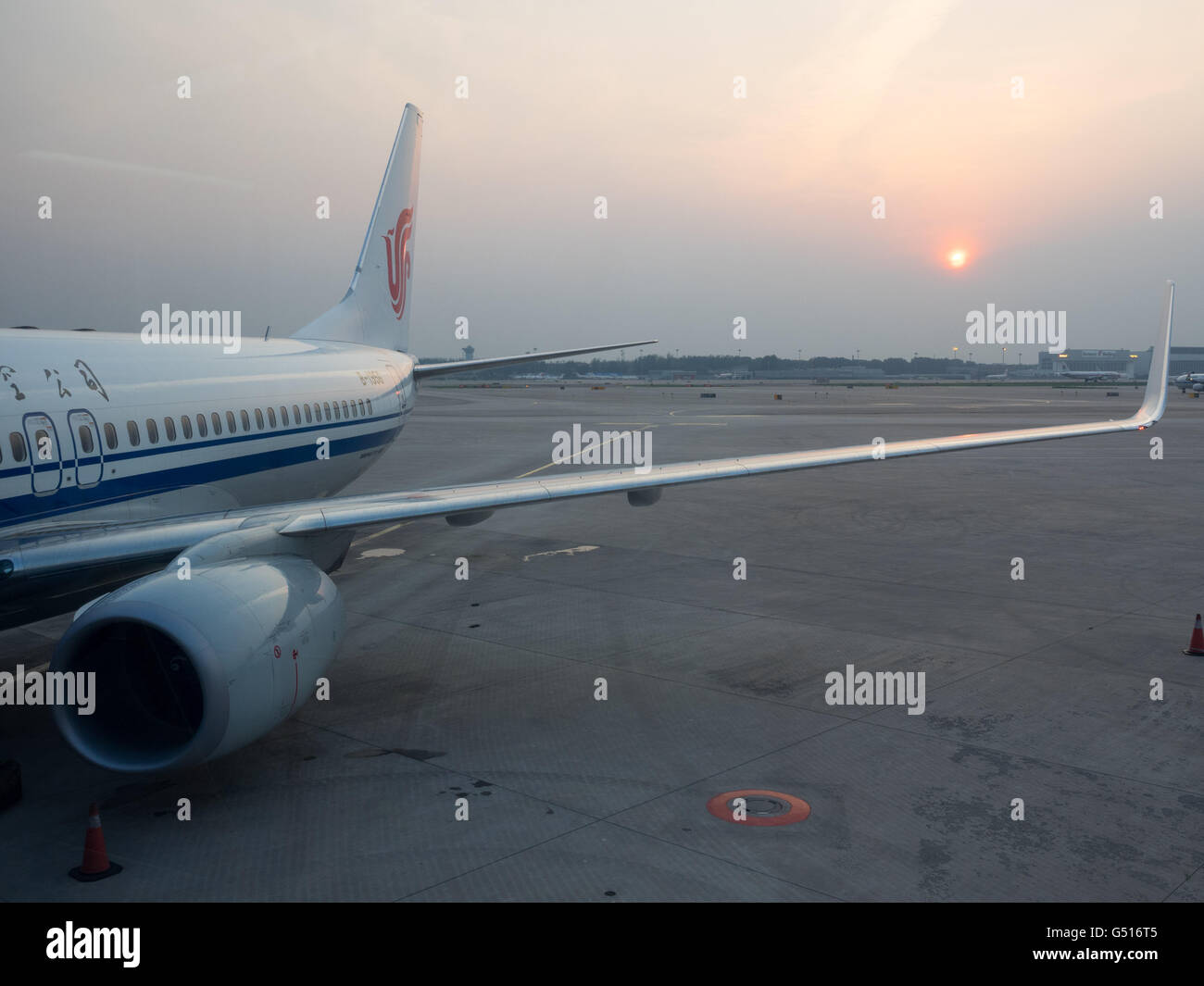 La Chine, Beijing, avion à l'Aéroport International avec le coucher de soleil en arrière-plan Banque D'Images