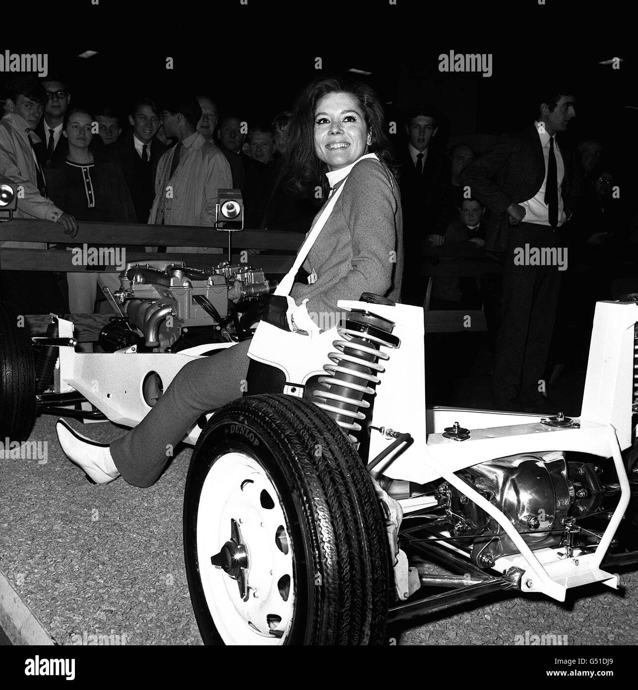 L'actrice Diana Rigg, qui joue Emma Peel dans la série télévisée The Avengerss', est assise sur les secrets d'un châssis Lotus Elan, sur le stand Lotus au Motor Show tenu à Earls court à Londres. DIANA RIGG DIANA RIGG Banque D'Images