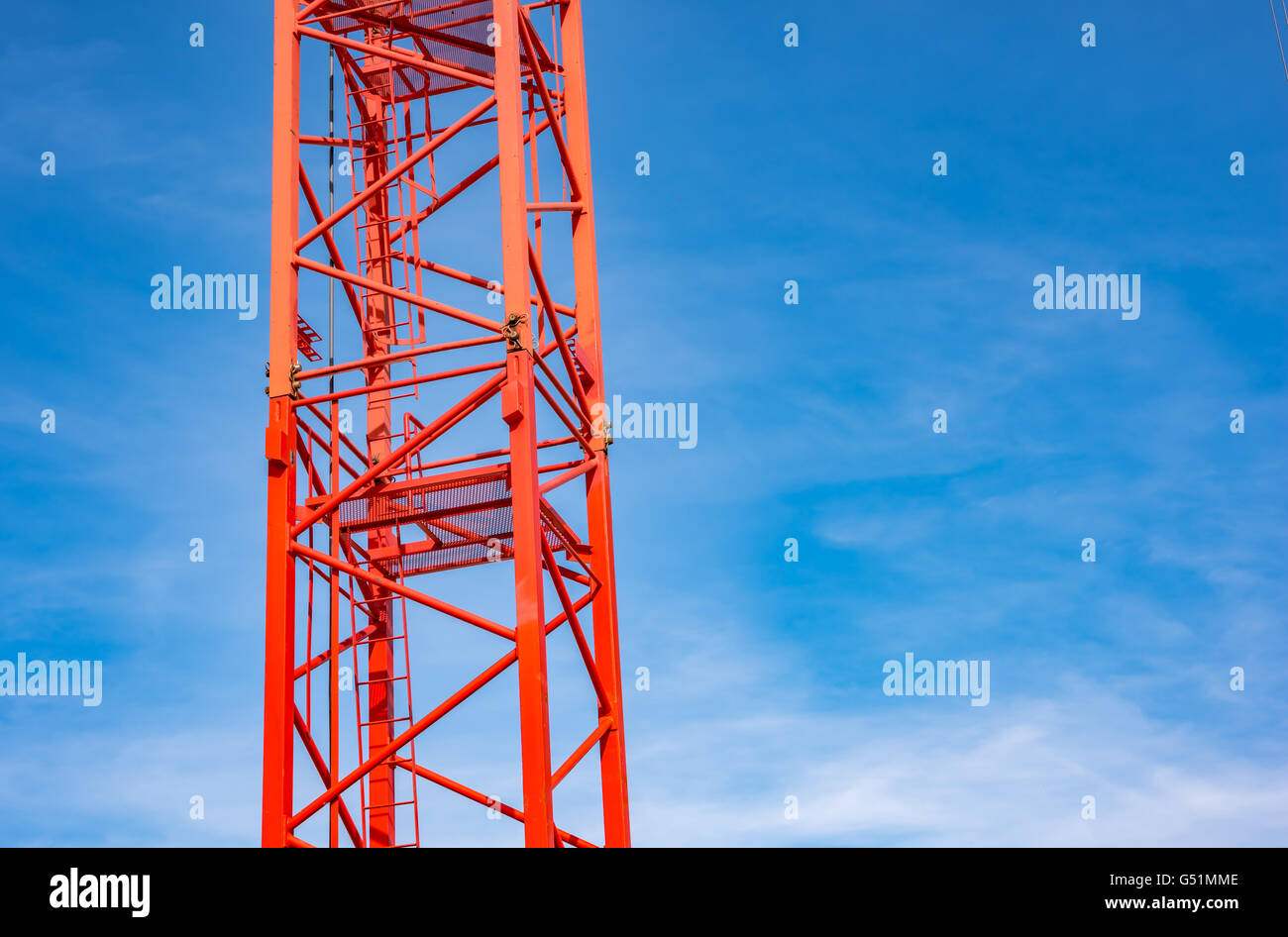 Grue de construction industrielle rouge contre le ciel bleu Banque D'Images