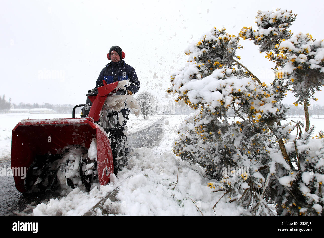 Un gardien de verdure élimine la neige des sentiers du Kings course à Gleneagles après la chute de neige, alors que plus de six pouces de neige sont tombés en l'espace de quatre heures dans certaines parties de l'Écosse pendant la nuit alors qu'un front de temps arctique s'est abattant sur le Royaume-Uni. Banque D'Images