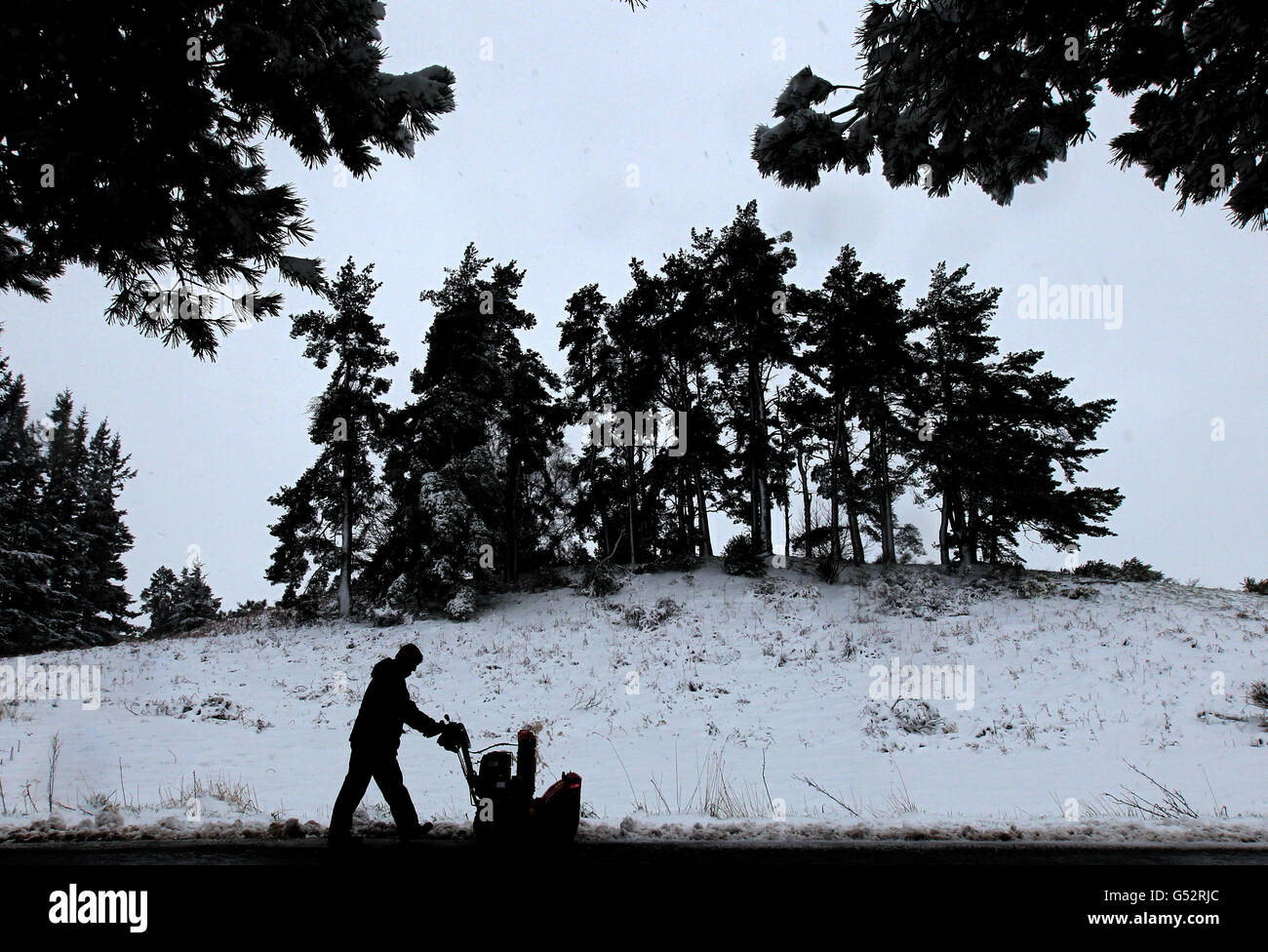 Un gardien de verdure élimine la neige des sentiers du Kings course à Gleneagles après la chute de neige, alors que plus de six pouces de neige sont tombés en l'espace de quatre heures dans certaines parties de l'Écosse pendant la nuit alors qu'un front de temps arctique s'est abattant sur le Royaume-Uni. Banque D'Images