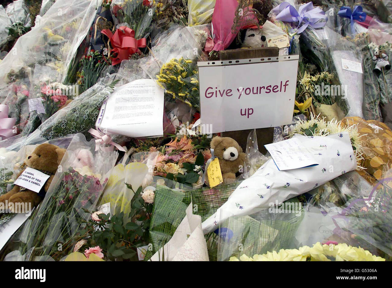 La masse de fleurs et de cartes de soutien continue de croître à côté de l'A29, près de Pulborough, dans le West Sussex, où le corps de Sarah Payne, âgée de huit ans, a été découvert le lundi 17 juillet 2000. Un morceau de papier est coincé avec « Donnez-vous » dessus. Banque D'Images