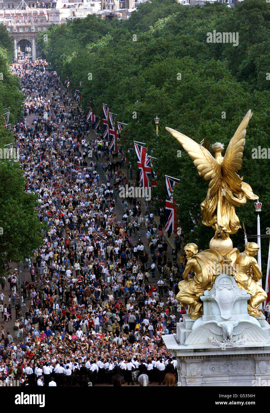 Les foules marchent vers le Queen Victoria Memorial dans le Mall, Londres, pour regarder des membres de la famille royale apparaître sur le balcon de Buckingham Palace dans le cadre des célébrations du 100e anniversaire de la Reine mère. La reine mère a reçu le message traditionnel d'anniversaire de sa fille, la reine Elizabeth II, avant de se rendre au palais de Buckingham dans une calèche à toit ouvert avec son plus vieux petit-fils, le prince Charles. Banque D'Images