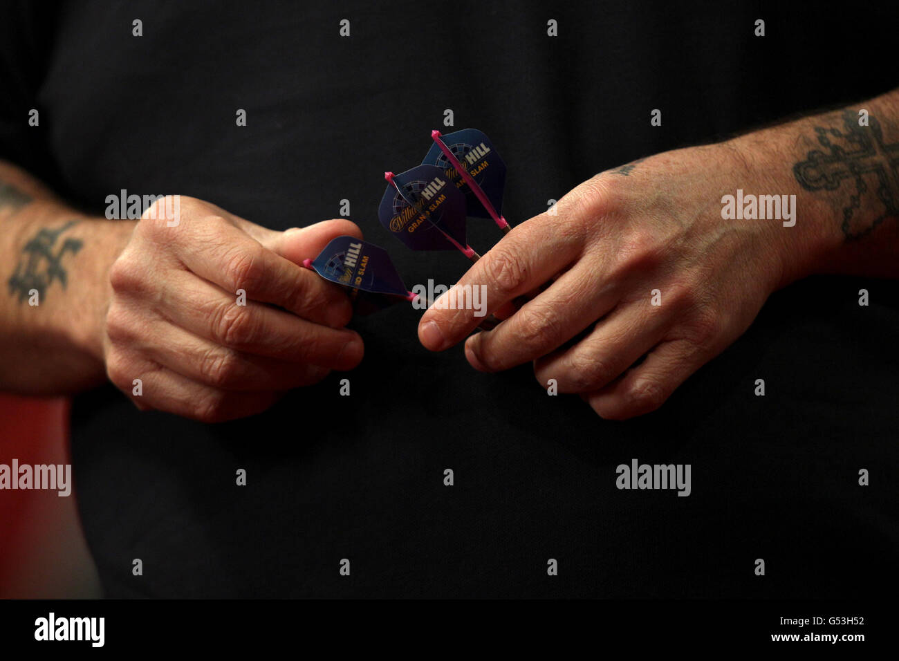 Fléchettes - McCoys Premier League fléchettes - Capital FM Arena.Phil Taylor tient ses fléchettes entre ses mains Banque D'Images