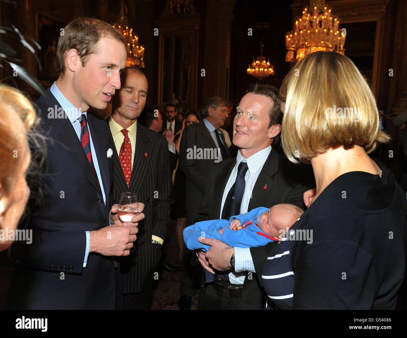 Le duc de Cambridge s'entretient avec Vic Vicaire, qui tient son fils Hugo Eric Scott Vicaire, âgé de trois semaines, et sa femme Hanna lors d'une réception pour célébrer la course du centenaire Scott-Amundsen au pôle Sud, au Goldsmitths Hall, dans la ville de Londres. Banque D'Images