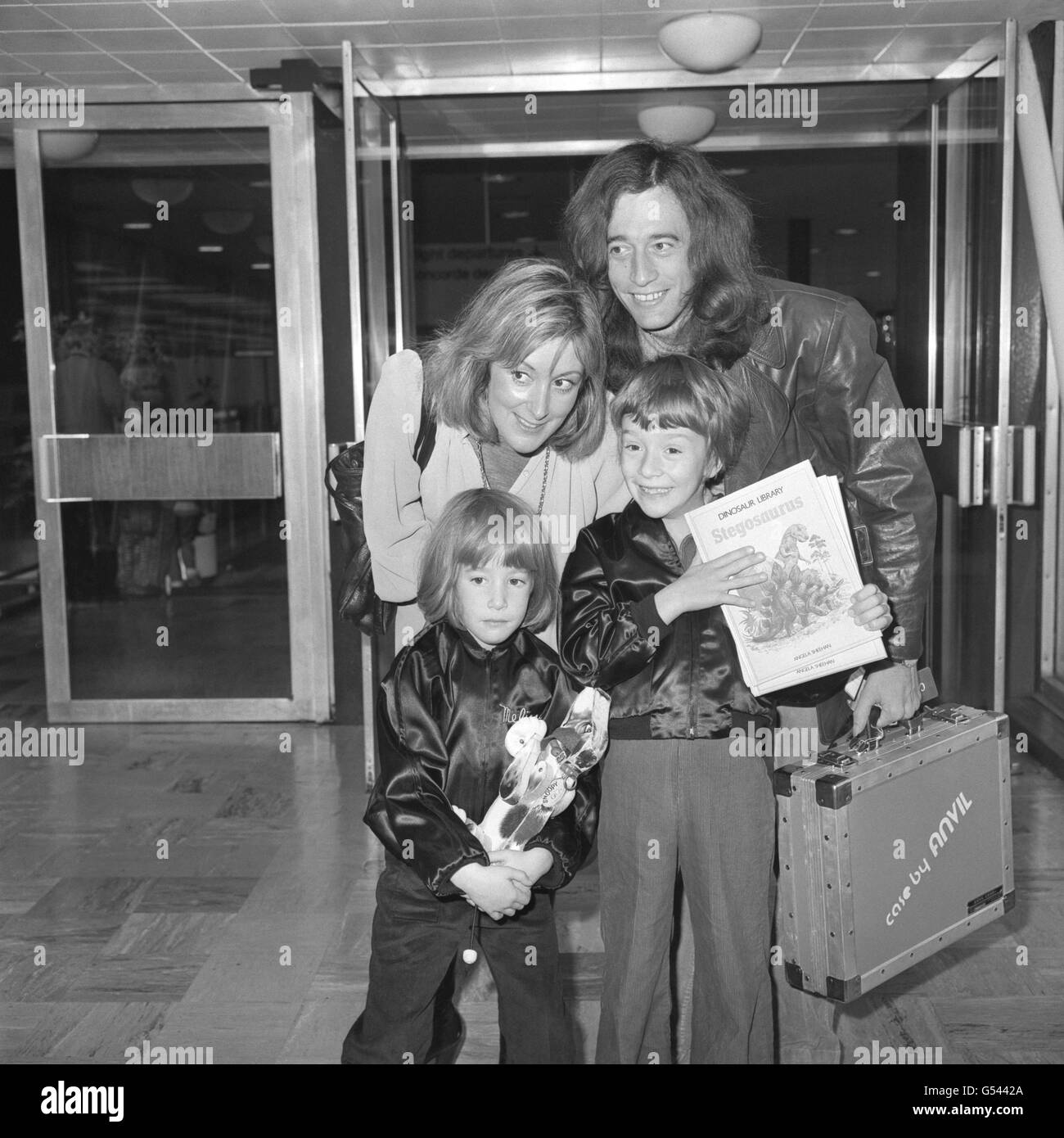 Robin Gibb du groupe pop Bee Gees, sa femme Molly et ses enfants, Melissa, cinq ans, et Spencer, sept ans, à l'aéroport de Londres Heathrow avant de prendre l'avion pour Concorde aux États-Unis. Banque D'Images