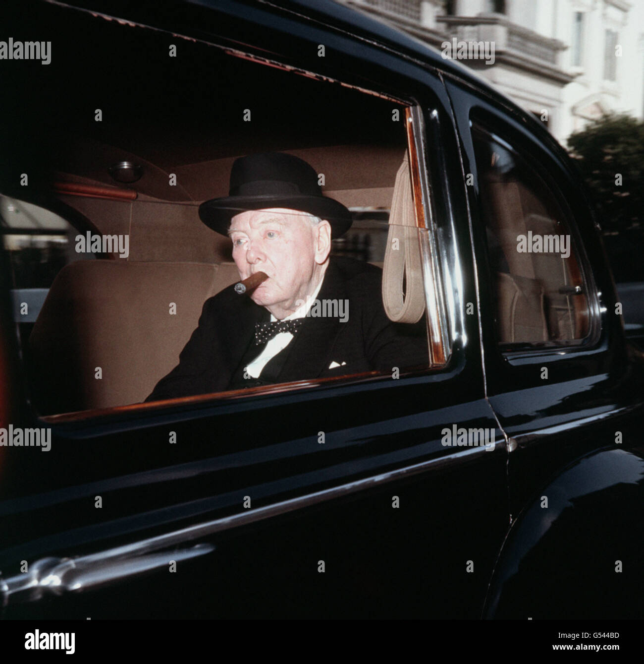Fume son cigare, Sir Winston Churchill quitte peut-être sa maison de Londres pour la Chambre des communes pour la dernière fois. Banque D'Images