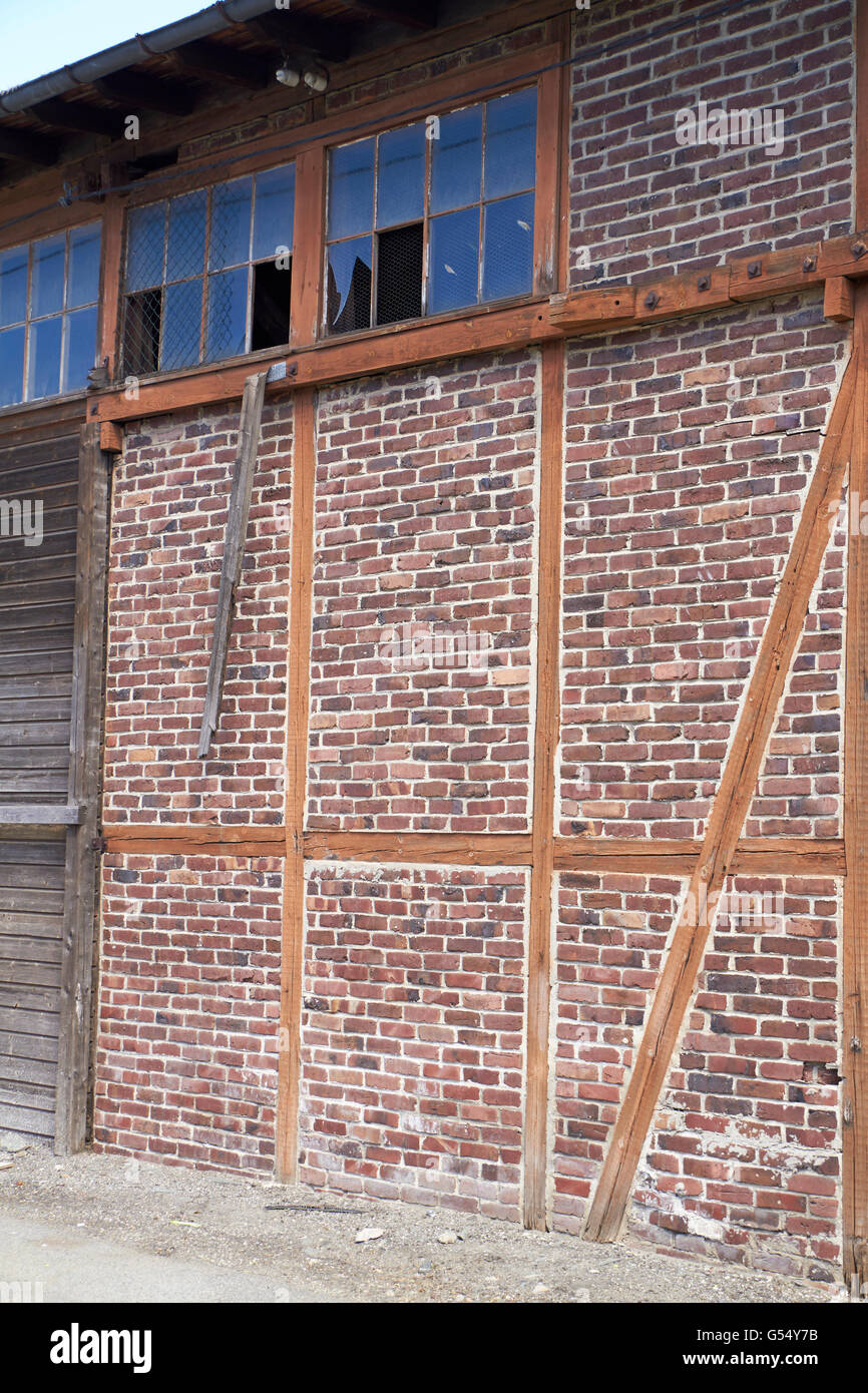 Vieux bâtiment en brique et en bois avec des fenêtres cassées Banque D'Images