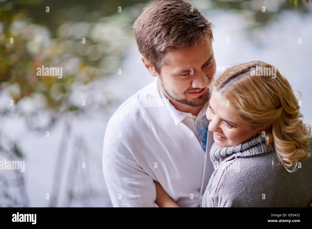 Heureux les femmes enceintes et son mari au cours de la marche avec un homme près du lac Banque D'Images