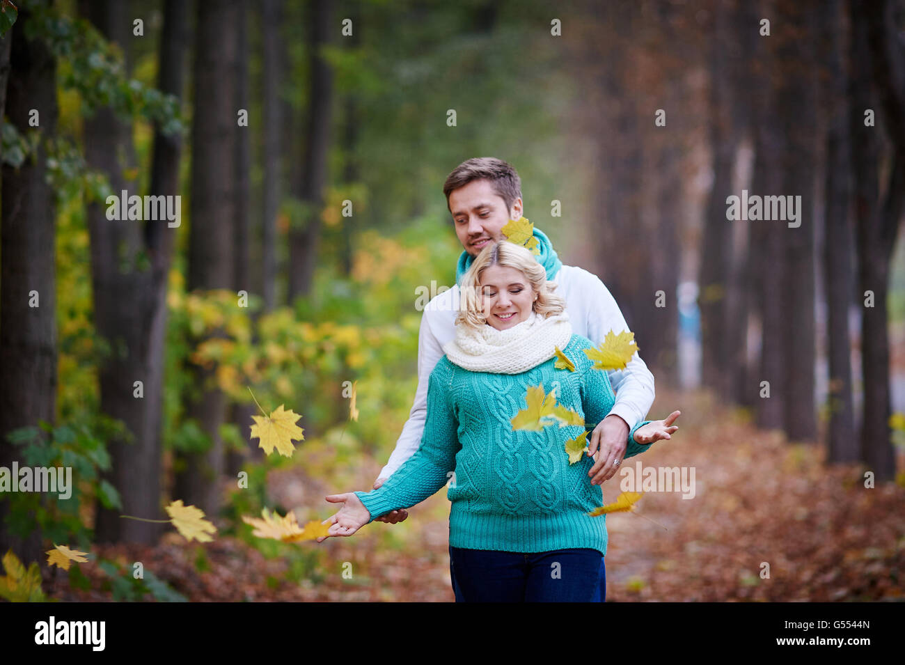 Mari et femme enceinte sont à pied dans le parc en automne Banque D'Images