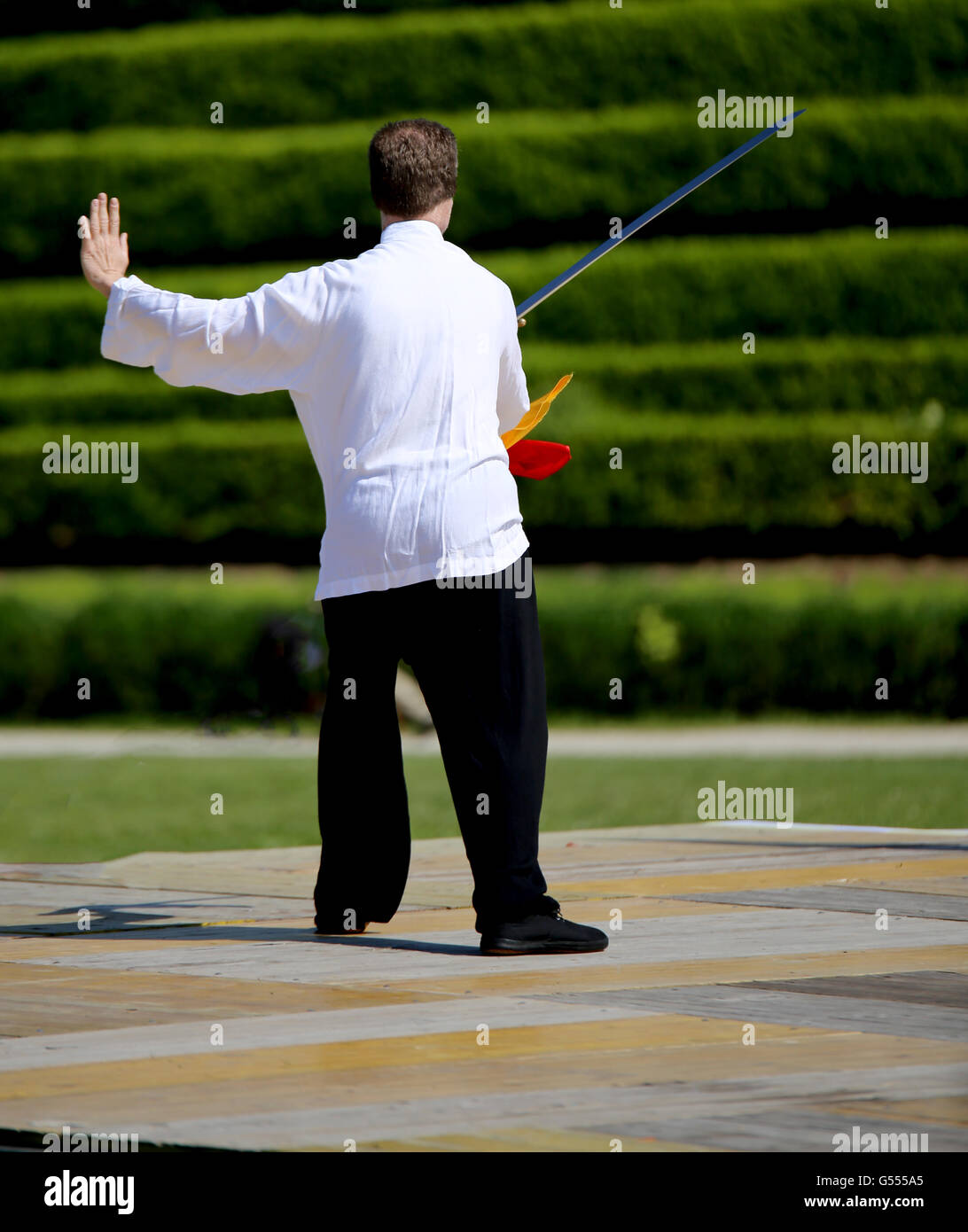 Maître expérimenté des arts martiaux Tai Chi est la formation avec épée aiguë en parc public Banque D'Images