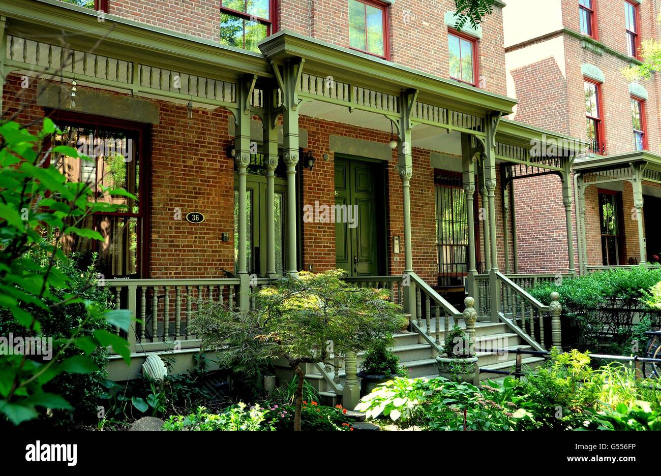 La ville de New York : vers 1900 Astor Row row brique maisons aux porches en bois victorien sur West 130e Rue à Harlem Banque D'Images