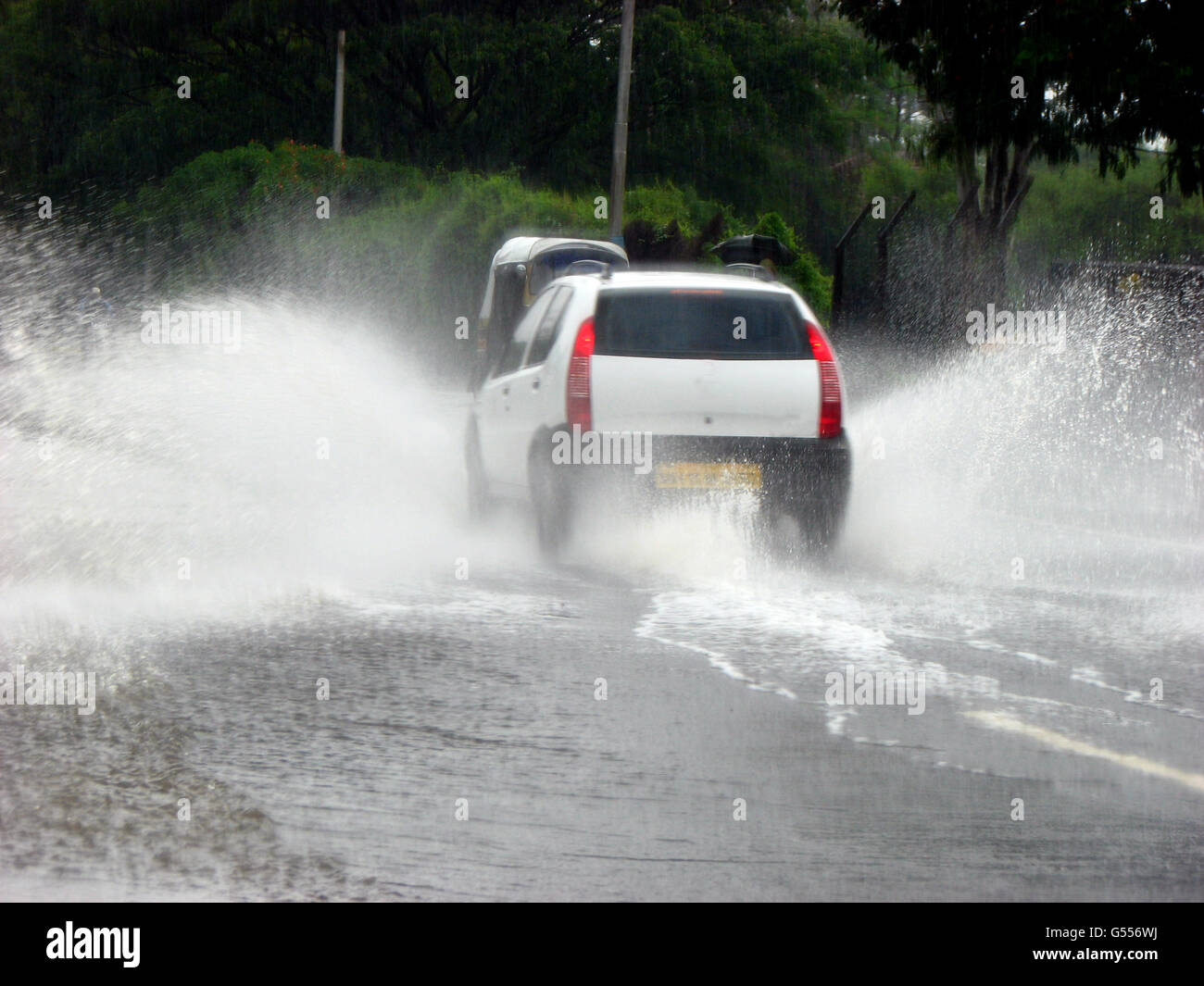 Une voiture au cours de l'eau éclaboussant par les moussons indiennes Banque D'Images
