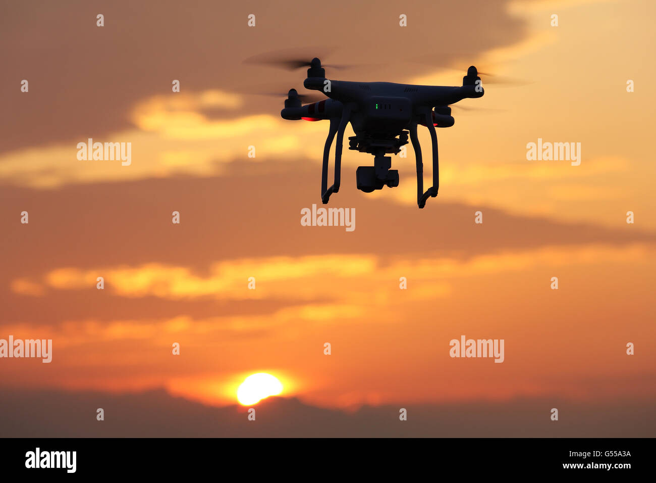 Drone voler contre un ciel de coucher du soleil Banque D'Images