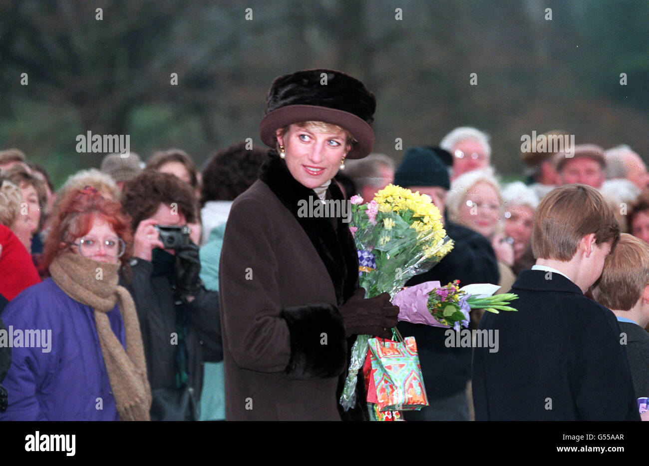 Diana, princesse de Galles, avec ses fils le prince William (2e à droite) et le prince Harry (extrême à droite), portant des fleurs d'un puits après avoir assisté au service du jour de Noël sur le domaine de Sandringham. * où les membres de la famille royale se réunissent traditionnellement pour les vacances de Noël. Banque D'Images